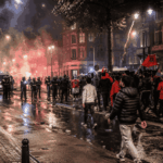 Politie en supporters op straat na een voetbalwedstrijd in een Europese stad