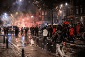 Politie en supporters op straat na een voetbalwedstrijd in een Europese stad
